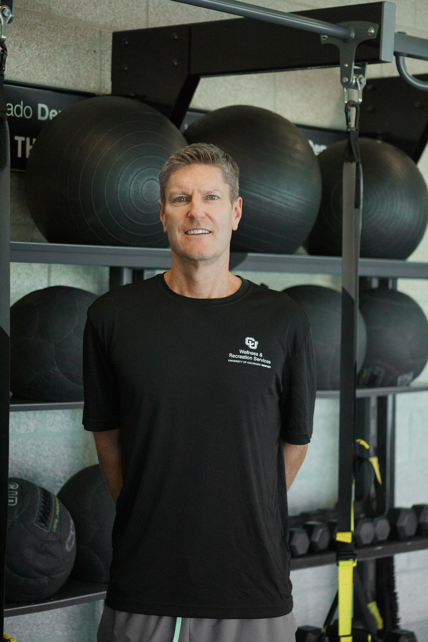 Brett the fitness instructor standing and smiling at the gym