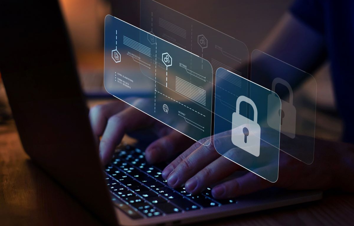 Image of a person using a laptop with a lock signifying secure computing.