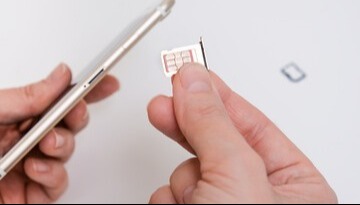 Image of person putting in SIM card into phone