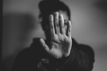 Person holding their hand in front of their face to signal Person holding their hand in front of their face to signal