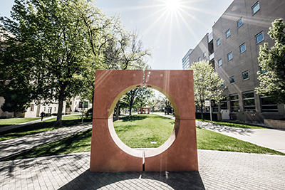 Sun over sculpture on campus