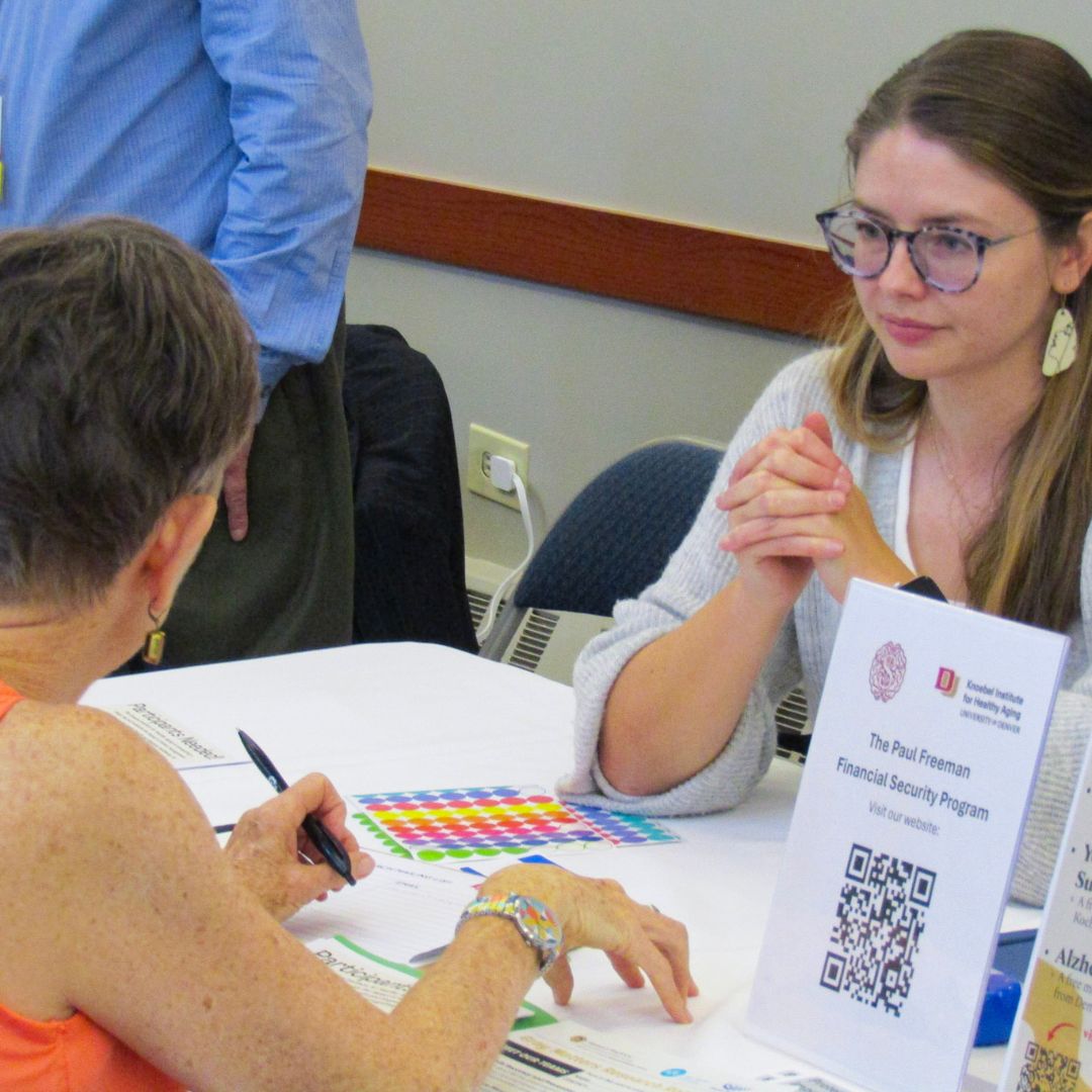Attendee speaking with a research team.
