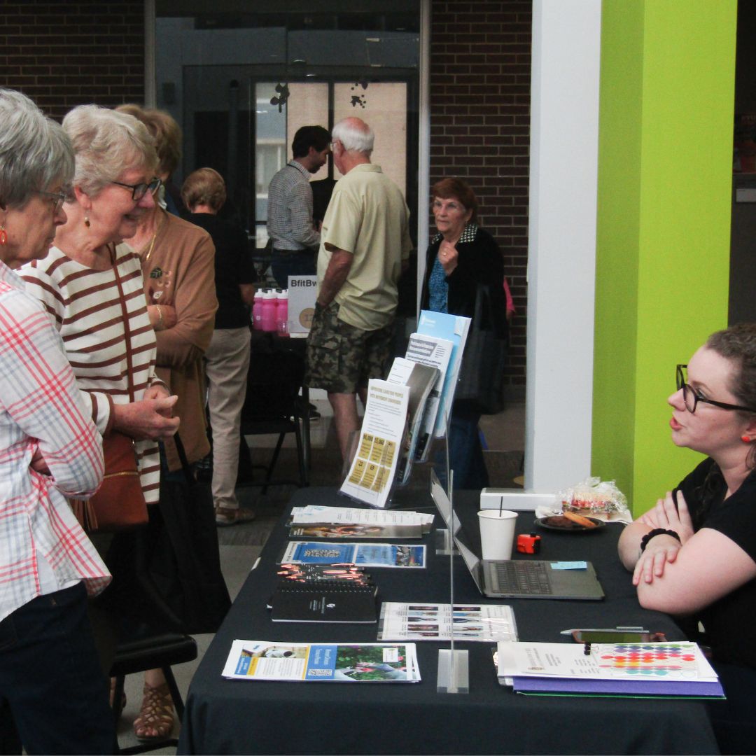 Attendees visiting a researcher table at the Sterling Research Roadshow.