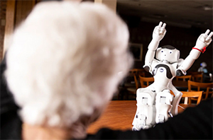 back of woman's head facing robot waving its arms