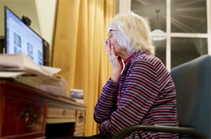 woman at computer with hand over mouth