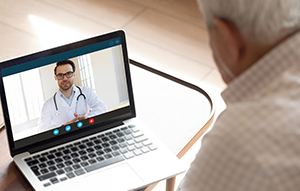 senior talking to health provider on computer