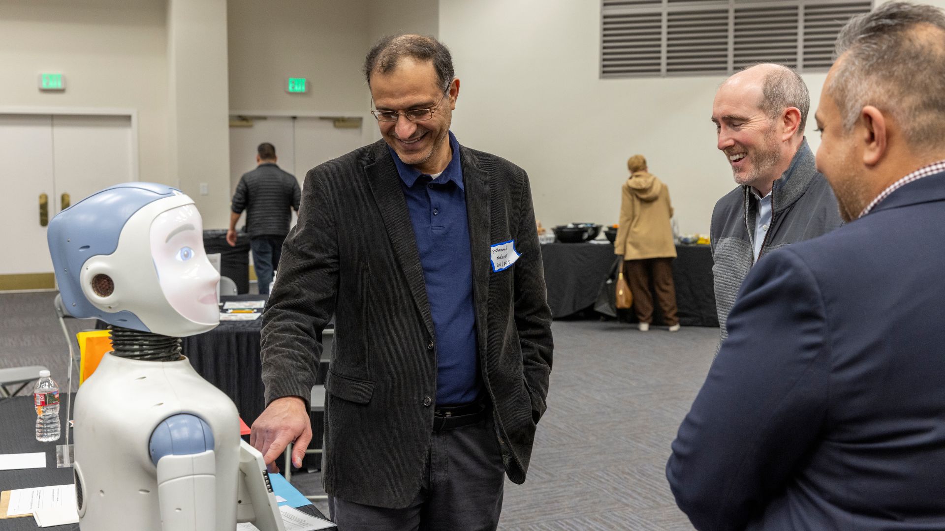 Participants interacting with Ryan the Robot at a Research Roadshow.