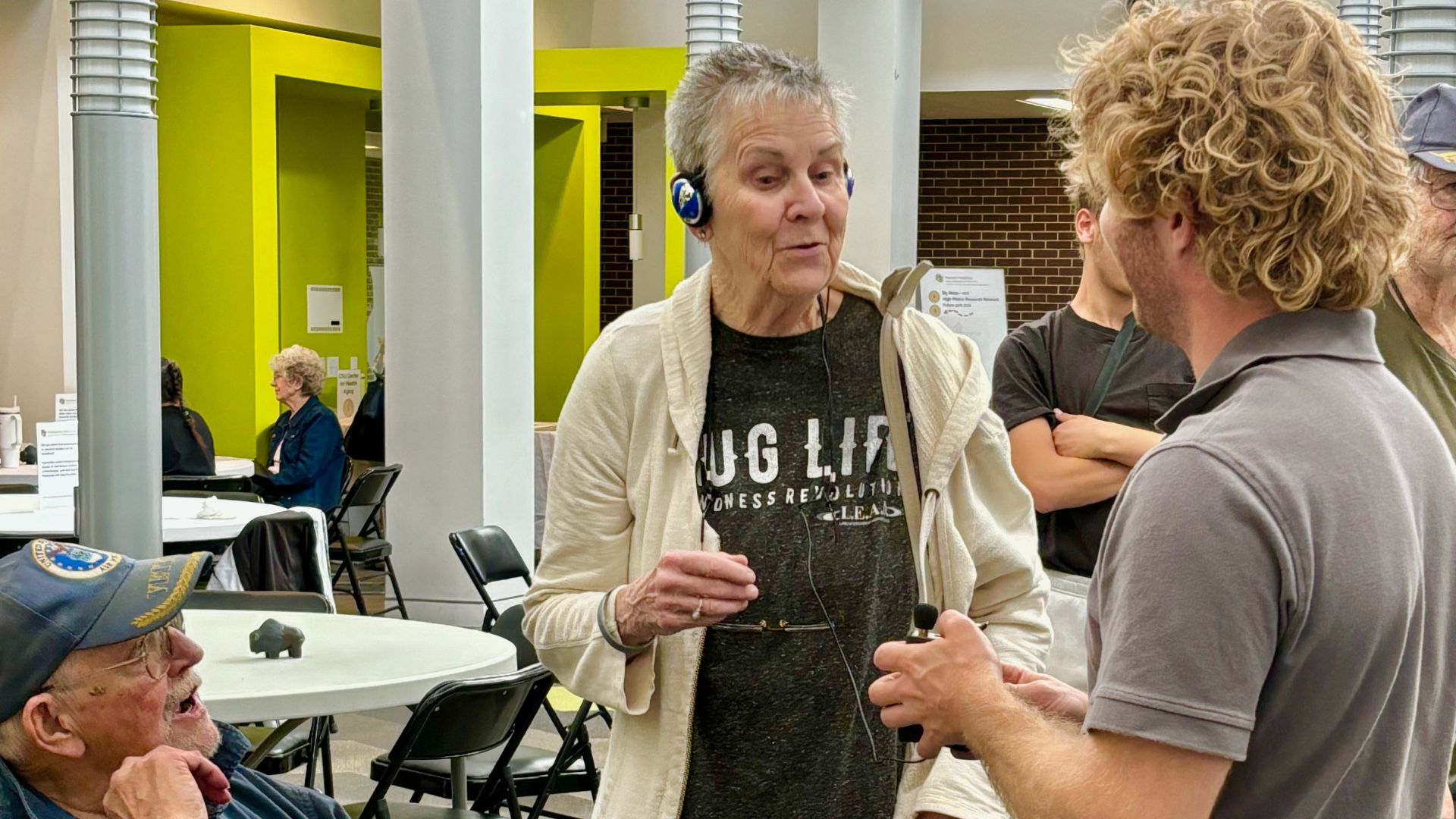 Participants trying out a hearing device at a Research Roadshow.