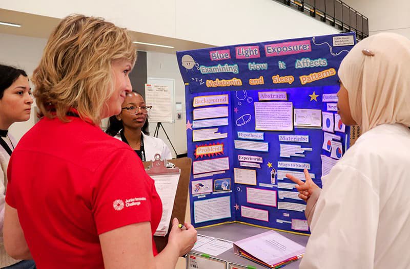 Student presenting a poster to judges.