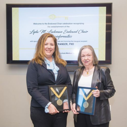 Dr. Stranger and Ms. Ludeman hold their honorary medallions while posing for a photograph.