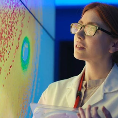 A scientist studies a projected scientific image on a screen.
