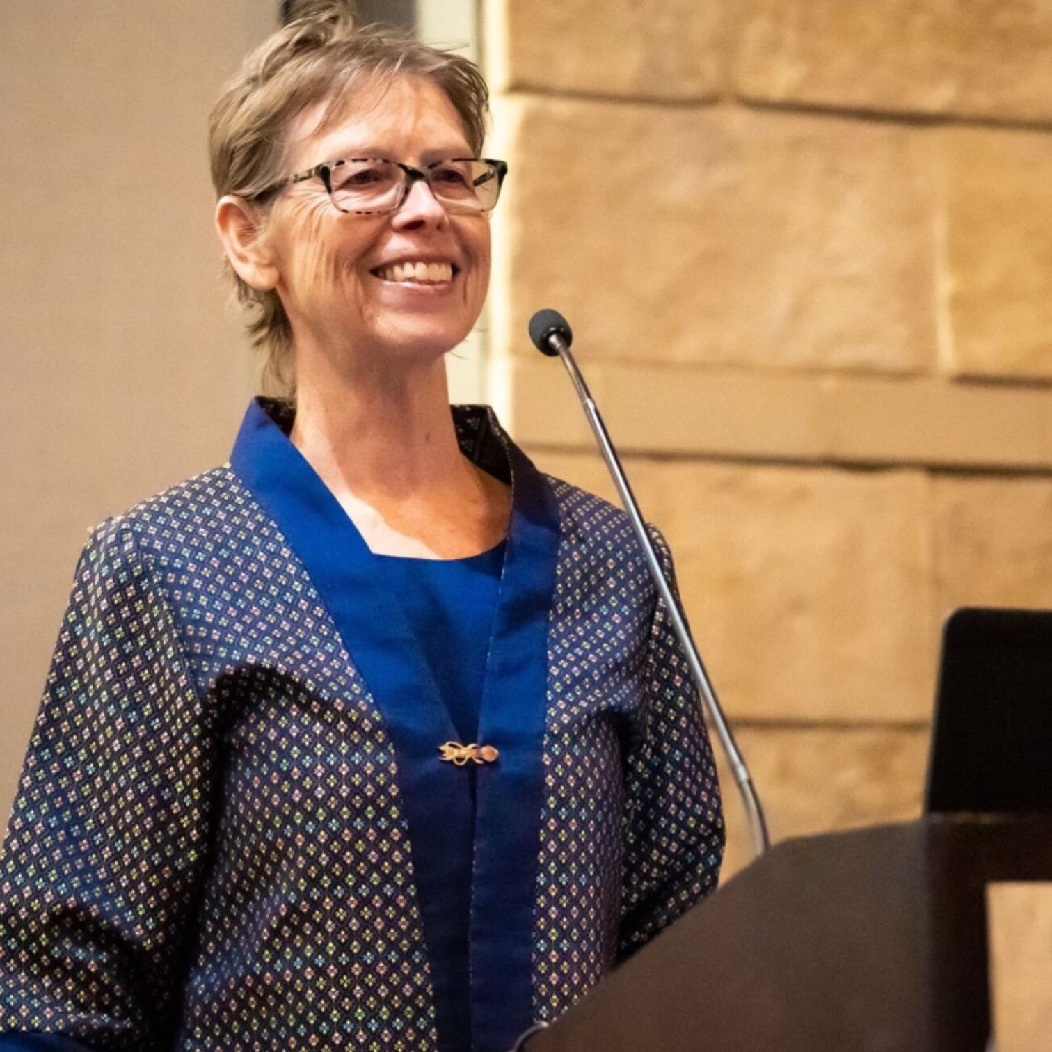 Kenda Fuller smiling as she gives a speech behind a podium.