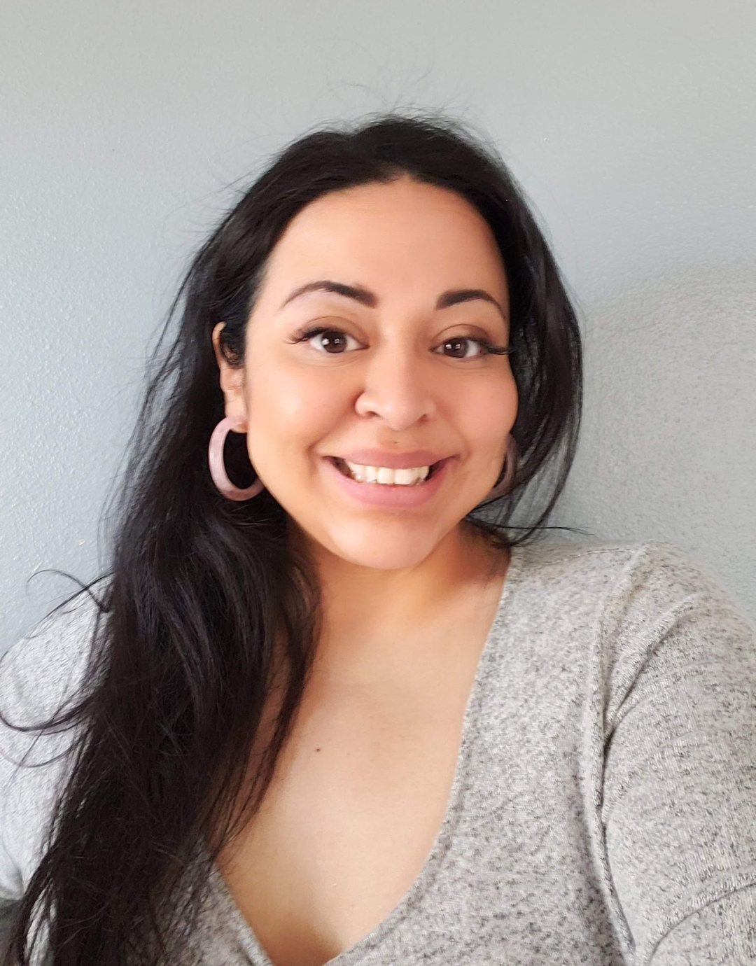 Ivy, indoors, smiling, in front of grey background