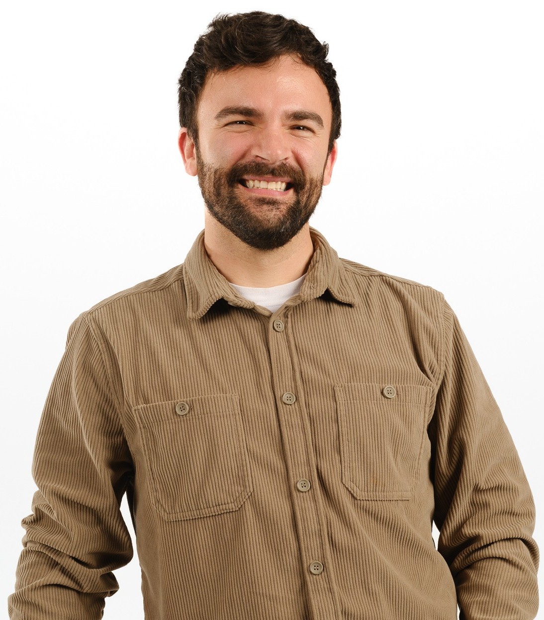 Nicolas, smiling, indoors, against a white background