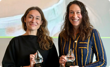 Dr. Lilia Cervantes and Dr. Stacey Simon holding awards