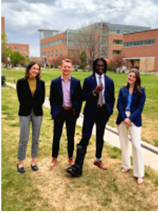 Four people standing on campus