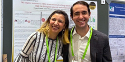 Two people in front of a poster