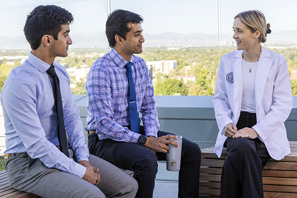 Students talking, seated on an education tower balcony