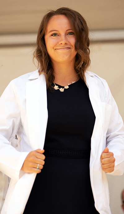 Matriculating student holding her white coat