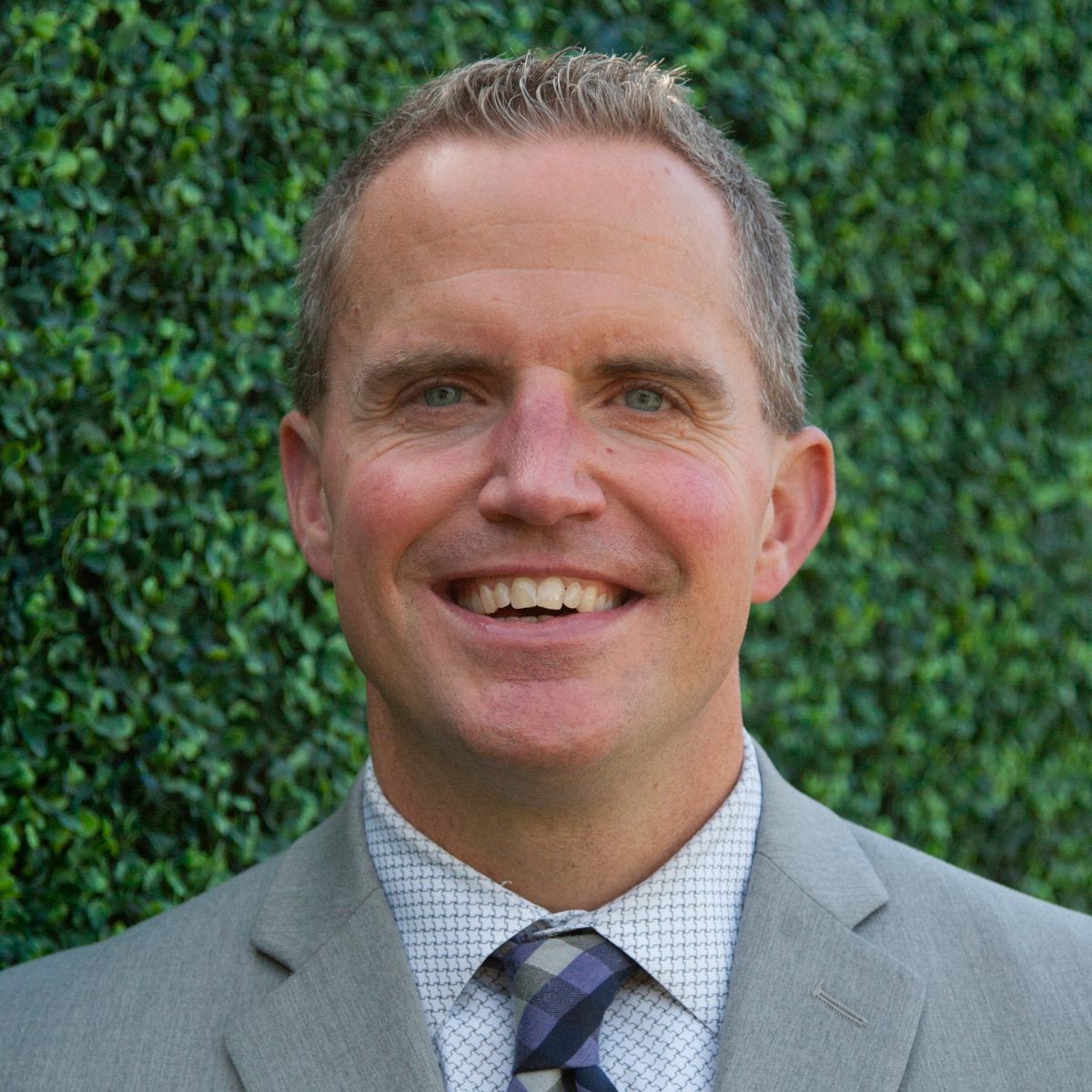 Man with styled hair in gray suit