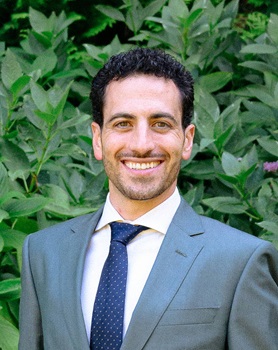 Esmaili Headshot Man with curly hair smiling