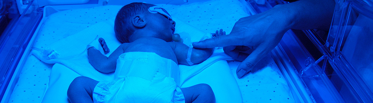baby in nicu in blue light