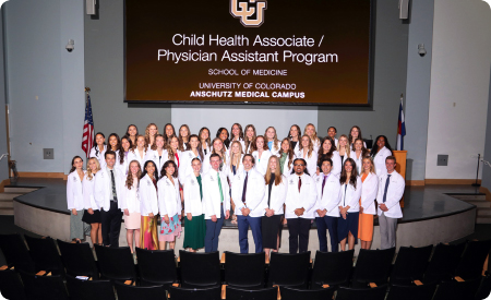 CU graduating class of PAs 2025 posing together on a stage