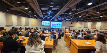 Symposium attendees looking at a presentation