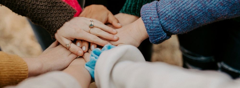 Hands piled on one another in a cirlce