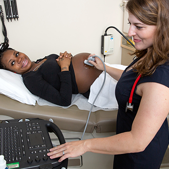 Doctor performing ultrasound on a pregnant woman.