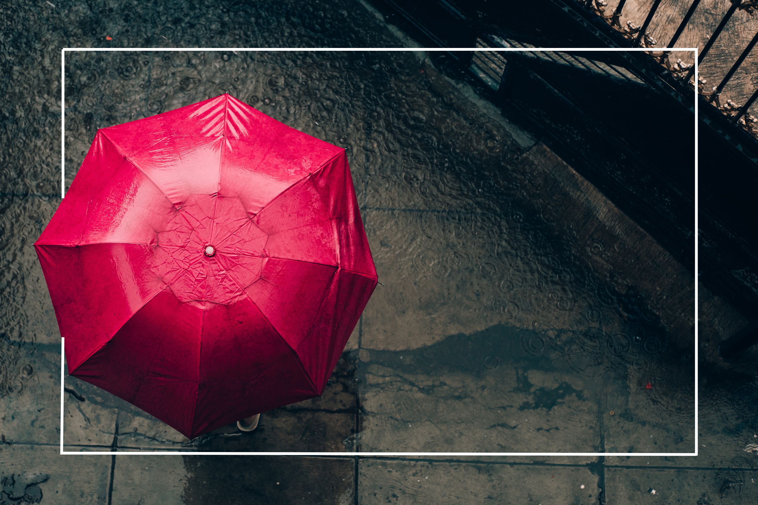 top down view on a red umbrella against a sidewalk