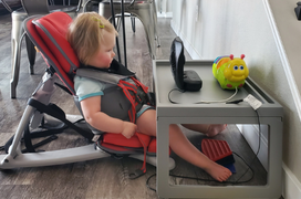a girl sitting in adaptive seating in front of an adapted fan