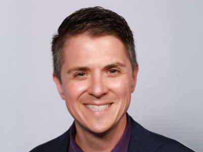 Man in collared shirt smiling