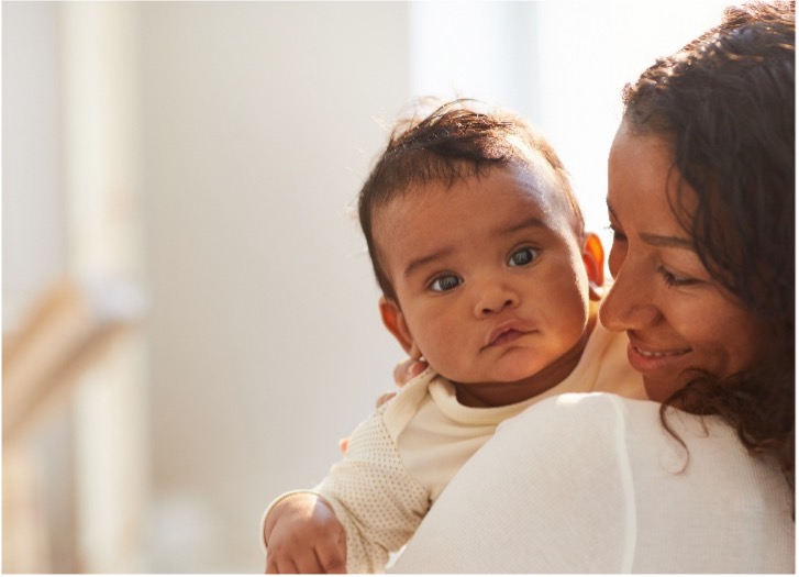 baby looking over woman's shoulder