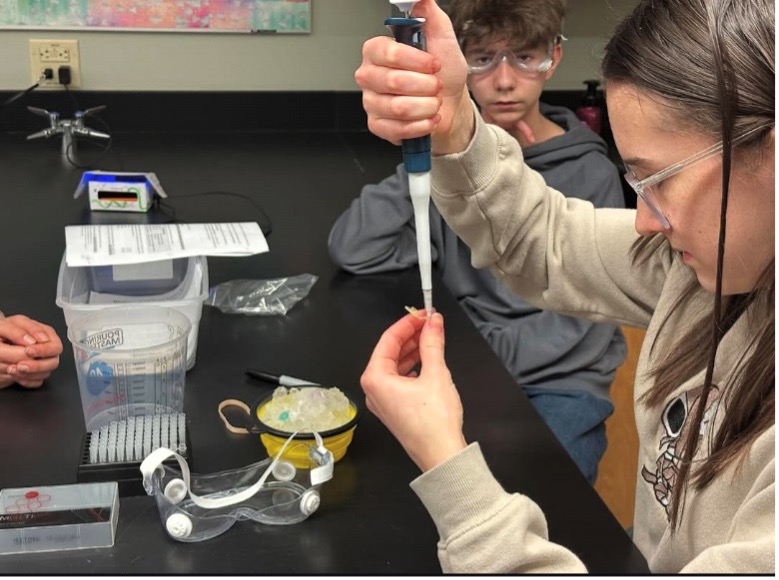 High school student using a pipette in a lab