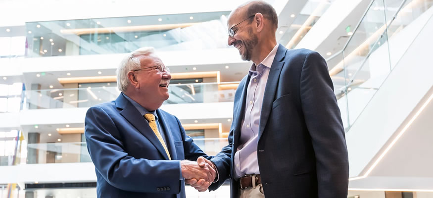 Dennis Roop, PhD, founding director of the Gates Stem Cell Program, shakes hands with Terry Fry, MD, who will become director of the new Gates Institute this fall