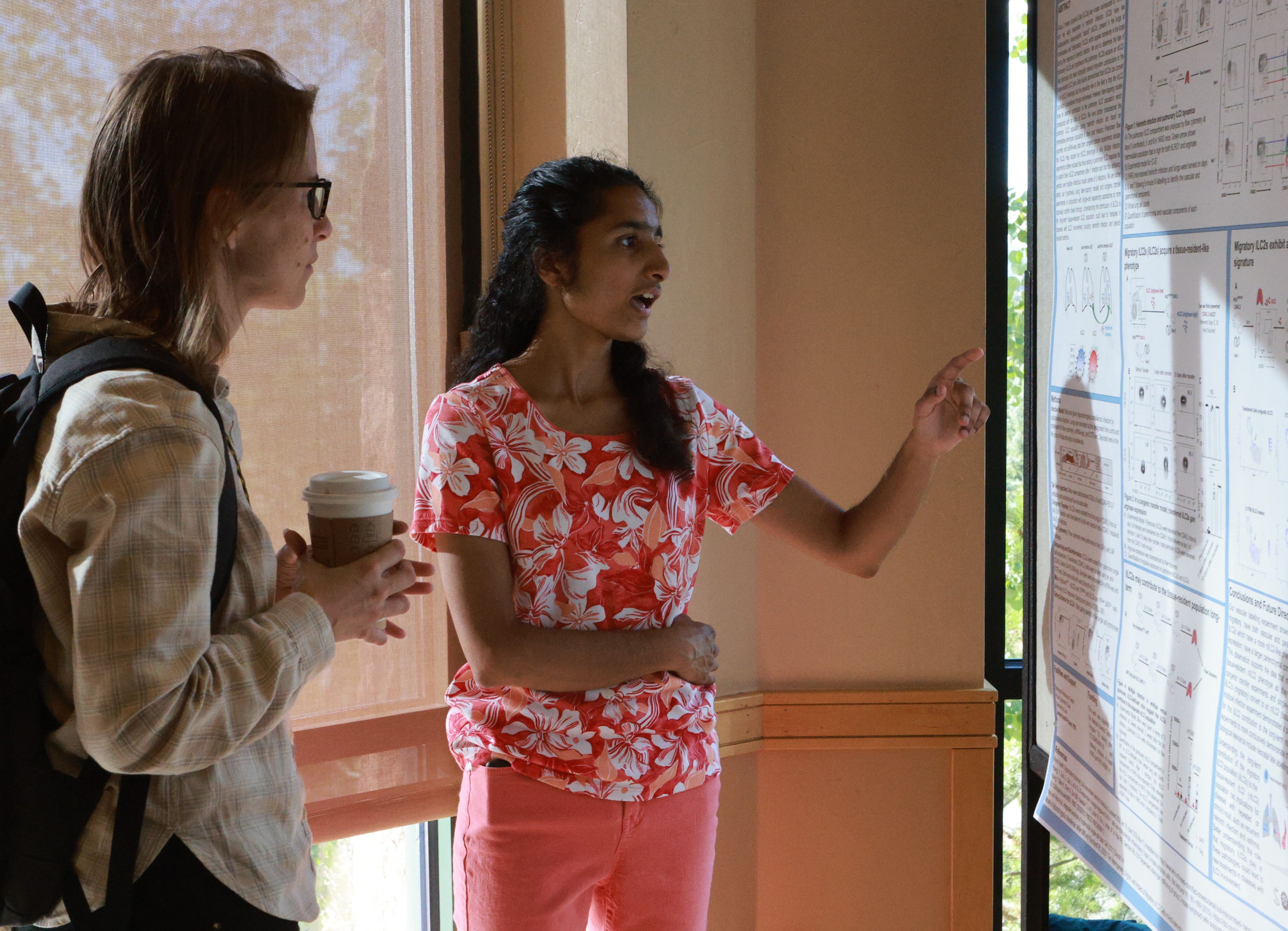 Scientist discussing abstract poster at the 2023 CIMC.