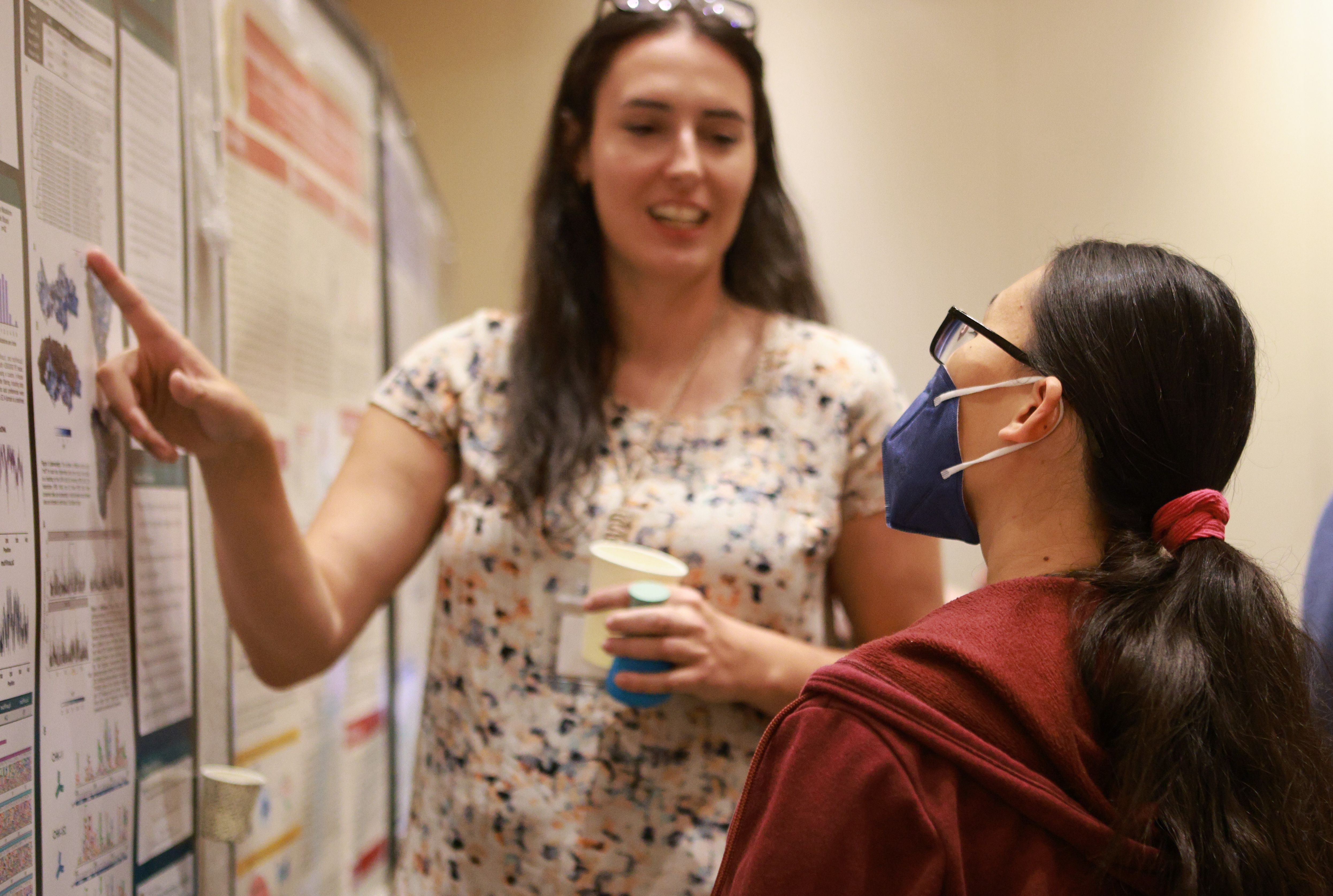 Scientist discussing abstract poster at the 2023 CIMC.