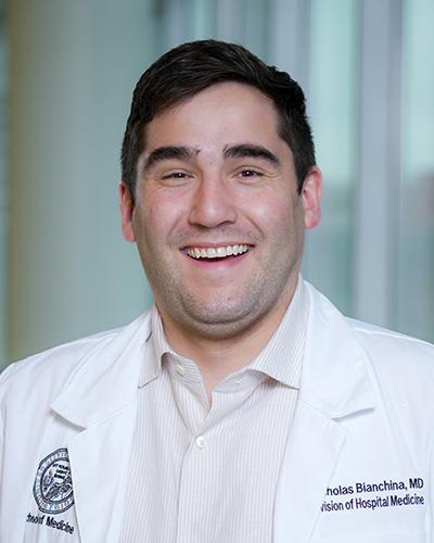 a doctor wearing a white coat, smiling