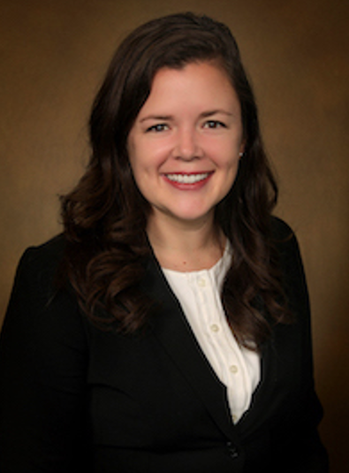 female doctor headshot in a black suit and white collared shirt