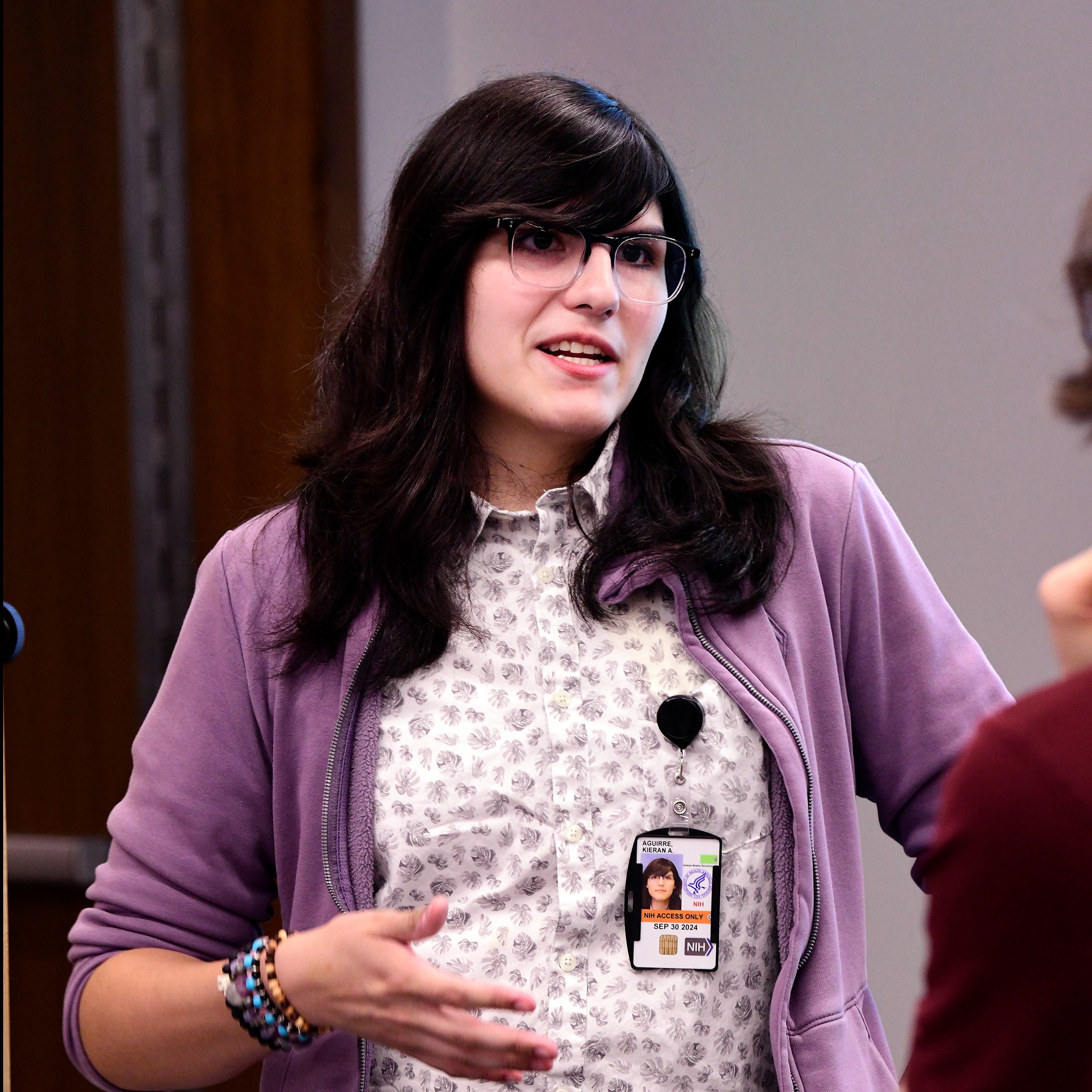 girl with dark hair, glasses, and purple blazers