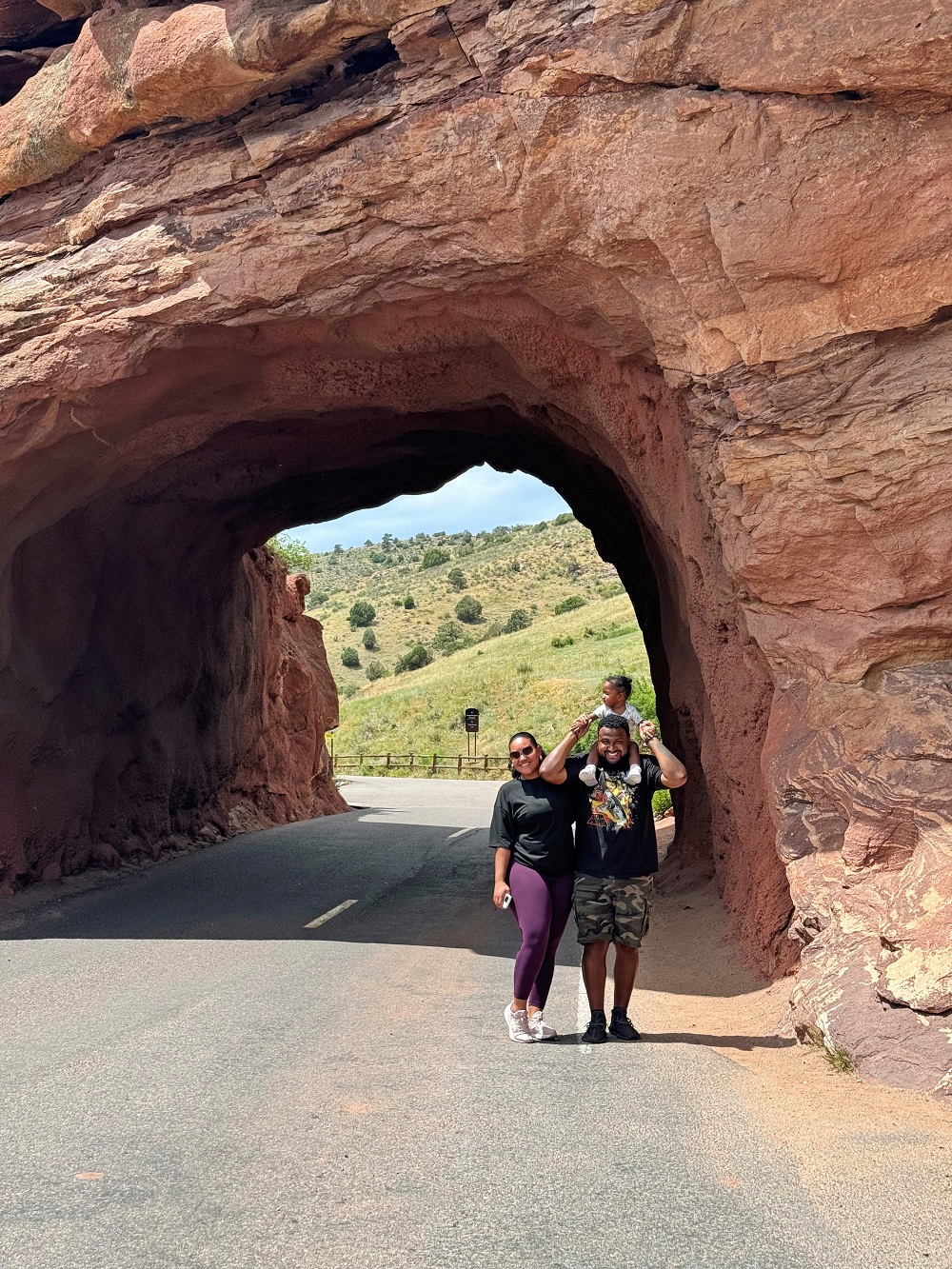 Photo of Dr. Ellis with a woman and young child under a rock arch.