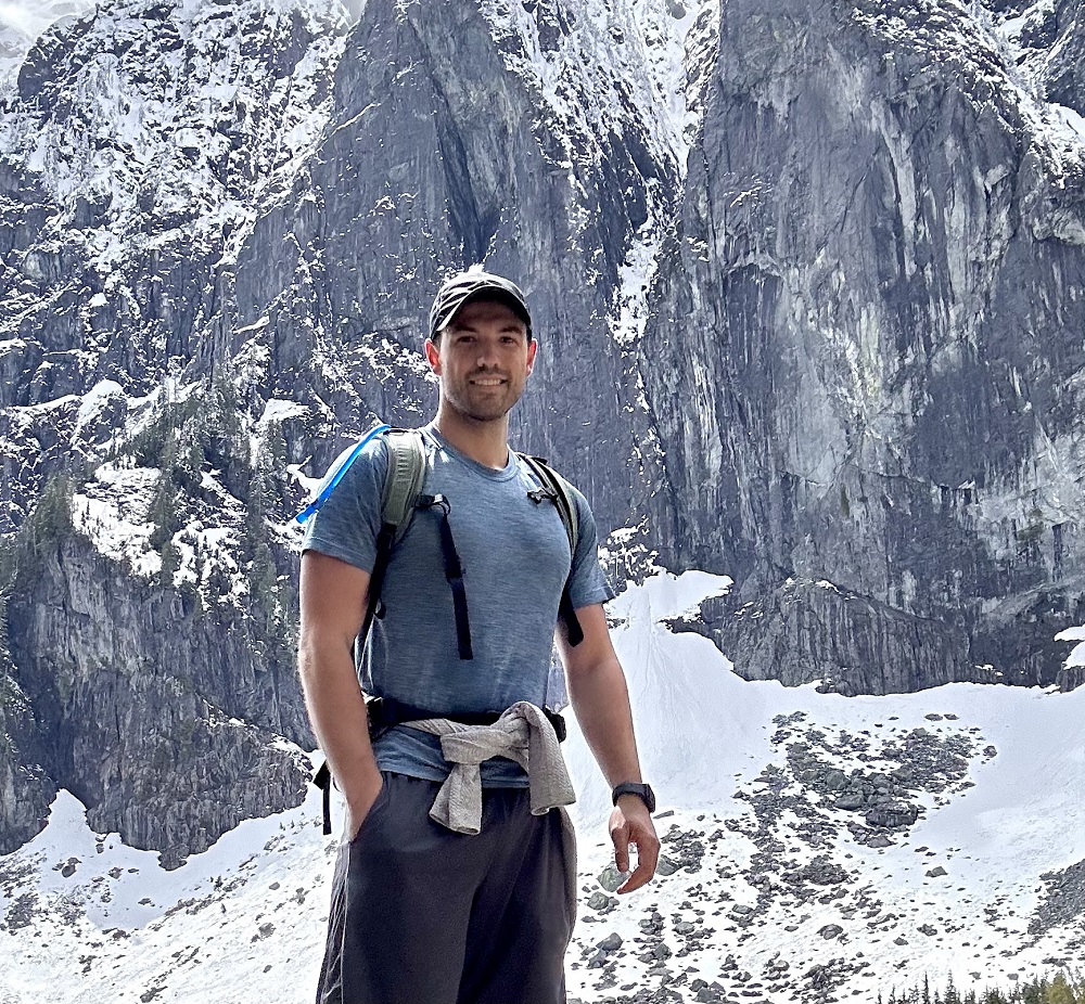 Photo of Dr. Malaska next to snow covered mountains.