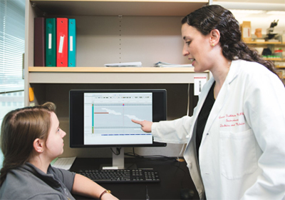 researcher instructing someone at computer