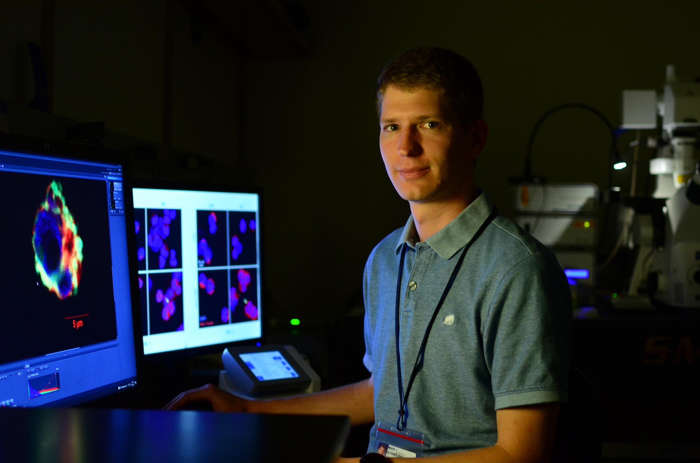 Jordan Althoff, PhD in front of microscope