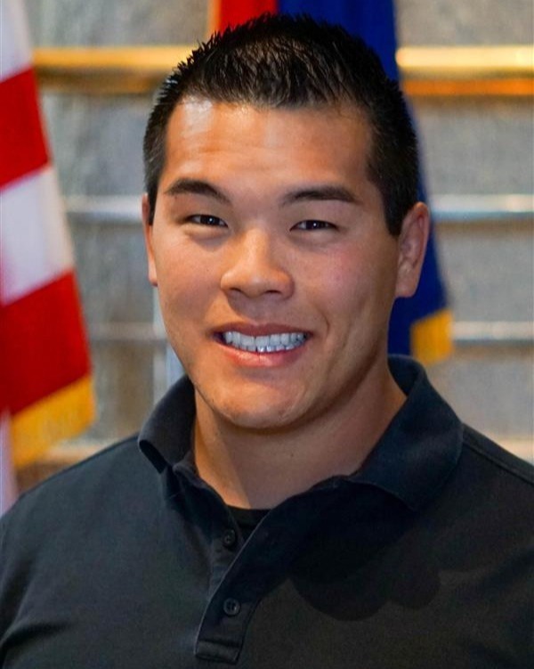 Headshot of man with flags behind
