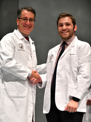 How to apply PA student in a white coat shaking hands with the program director