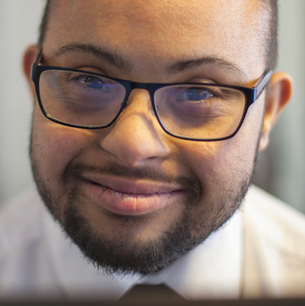 Man with Down syndrome wearing glasses and smiling.