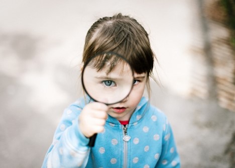 Girl looking through magnifying glass